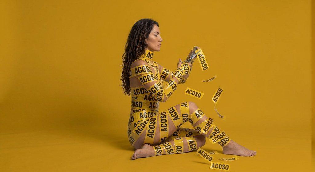 Fotografía conceptual sobre cómo superar el acoso laboral en Colombia: una mujer se libera de las cintas. Una metáfora para romper el silencio.